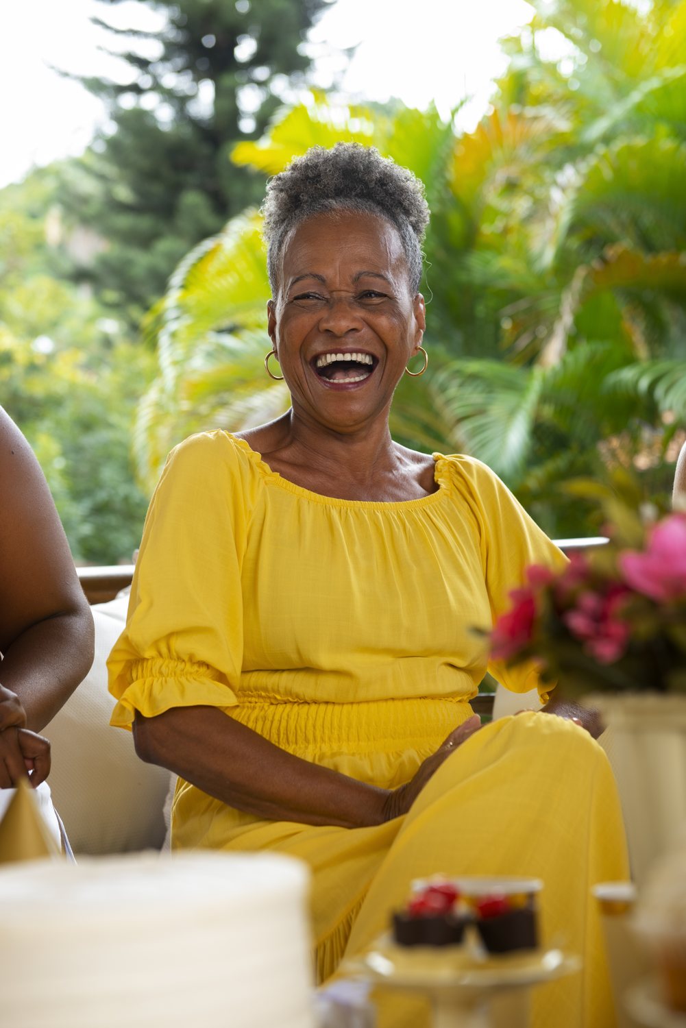 A woman in a yellow dress laughing with joy